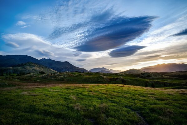 Landschaft mit dunklen Wolken und grünem Feld