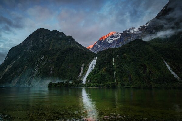 Bella cascata sullo sfondo di catene montuose