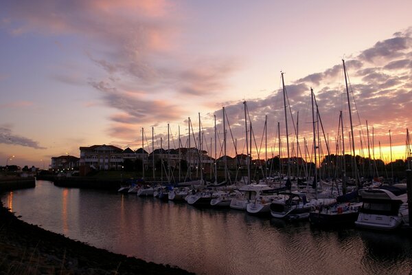 Cielo al atardecer sobre el muelle con reflejo en el agua