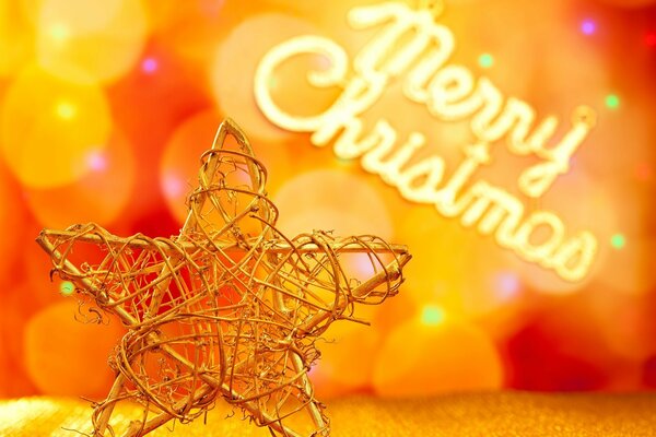 Металлическая елочная игрушка-звезда на фоне боке и надписи Merry Christmas